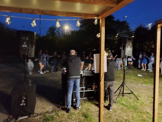 Tanzende Jugendliche an einem lauen Frühlingsabend mit den DJs im Vordergrund